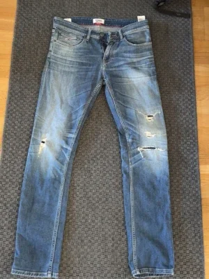 Blå slitna jeans från Tommy Jeans