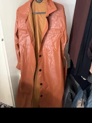 Brun lång skinnjacka med fickor