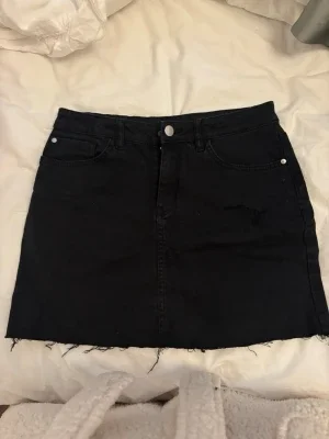 Svart jeanskjol med rå kant