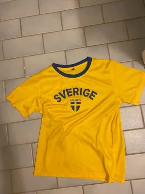 Gul Sverige t-shirt med blå detaljer