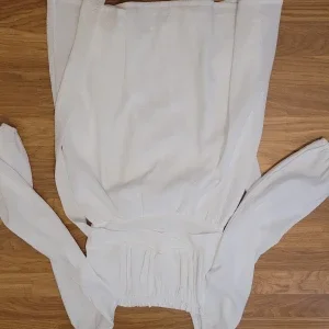 Vit långärmad klänning med smock i midjan