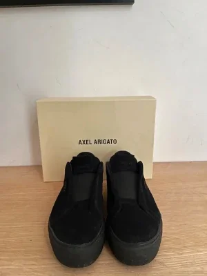 Svarta slip-on sneakers Axel Arigato