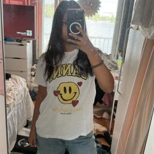 Vit t-shirt från Ganni med smiley