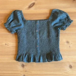 Blå smockad blus med puffärm från KappAhl