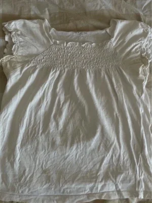 Vit blus med smock och volangärm