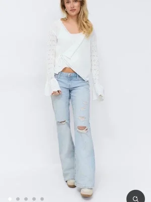 Ljusblå slitna bootcut jeans