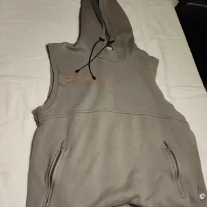 Grå ärmlös huvtröja från Asics