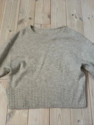Beige stickad tröja med ribbad kant