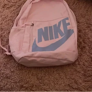 Ljusrosa Nike ryggsäck med blå logga