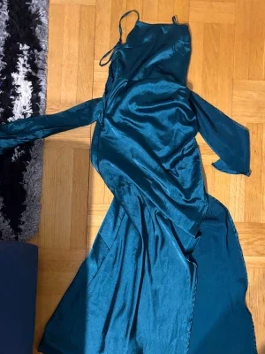 Lång blå satinklänning med öppen rygg