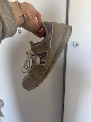 Beige New Balance sneakers med lila detaljer