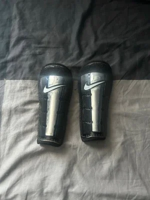Nike benskydd svarta och silver
