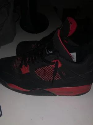Svarta och röda Air Jordan 4 sneakers
