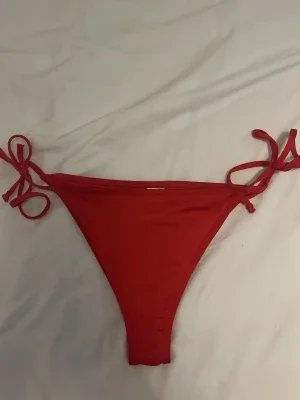 Röda bikiniunderdelar med knyt