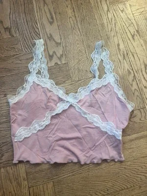 Rosa spetsbody med vita detaljer