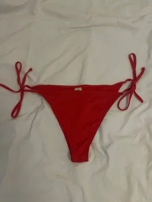 Röda bikiniunderdelar med knyt