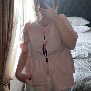 Ljusrosa blus med puffärm och knyt