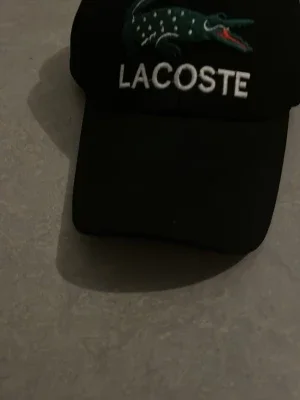 Svart Lacoste keps med brodyr