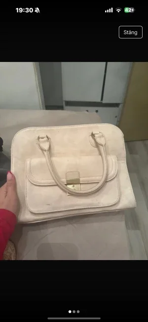 Beige handväska med gulddetalj