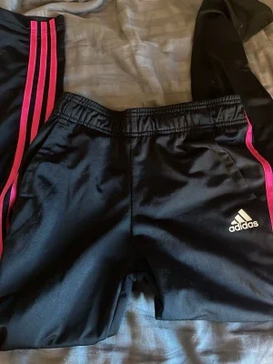 Svarta Adidas träningsbyxor med rosa ränder