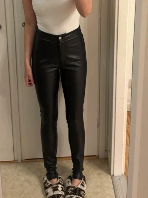 Svarta skinny byxor i fuskskinn