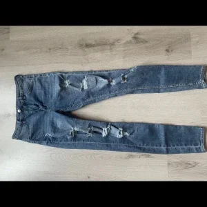 Blå slitna jeans