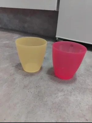 Två plastmuggar i gult och rosa