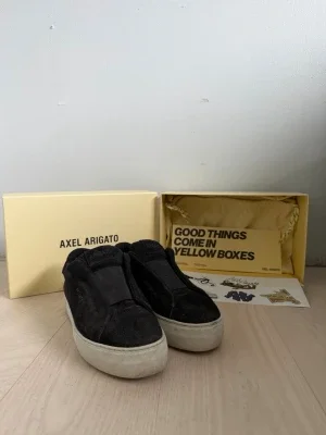 Svarta slip-on sneakers Axel Arigato