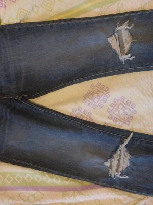 Mörkblå slitna jeans med hål