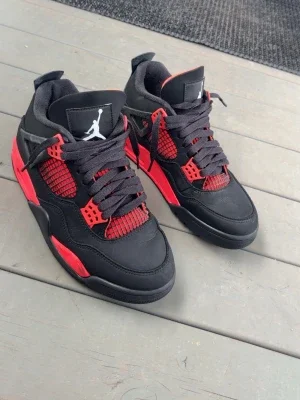 Svarta och röda Air Jordan 4 sneakers