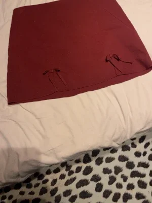 Vinröd kjol med rosetter