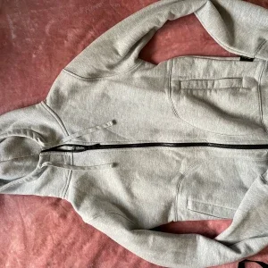 Grå hoodie med dragkedja och tumhål