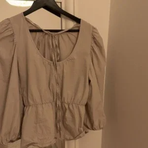 Beige blus med puffärm och knyt