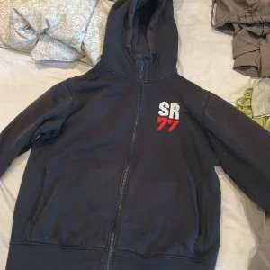 Svart hoodie Sail Racing SR77