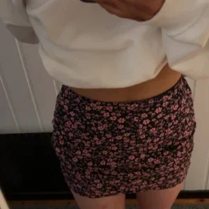 Svart minikjol med rosa blommor från H&M