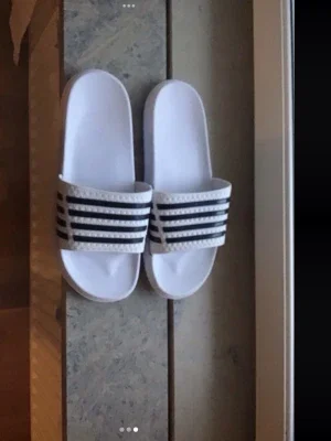 Vita Adidas badtofflor med svarta ränder
