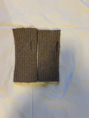 Beige stickade handledsvärmare