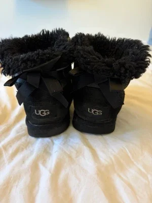 Svarta UGG uggs med rosetter