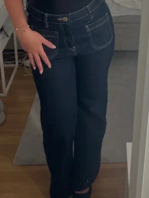 Mörkblå utsvängda jeans med kontrastsömmar