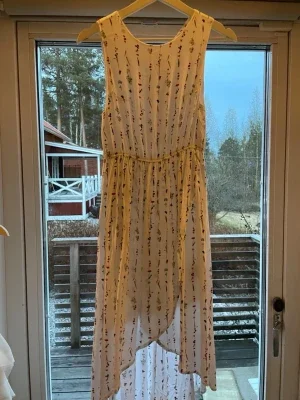 Vit barnklänning med blommigt mönster