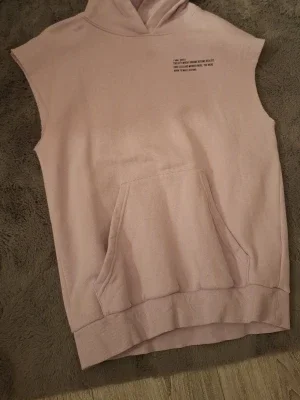 Ljusrosa ärmlös hoodie med tryck