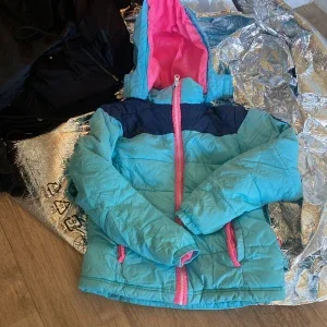 Turkos och marinblå vinterjacka med rosa detaljer