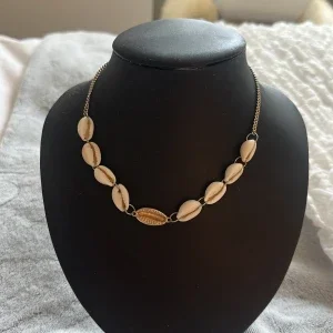 Halsband med snäckor och gulddetalj