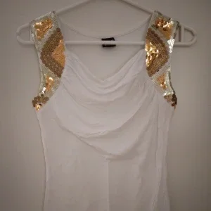 Vit ärmlös topp / linne med snygga glittriga detaljer / paljetter. Strlk: XS-S. Viskos. Gina Tricot.