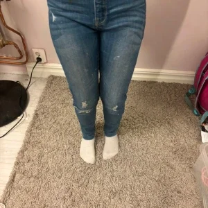 Blå skinny jeans med slitningar