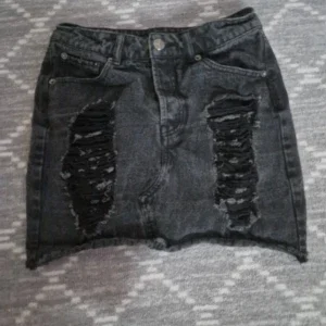 Svart jeanskjol med slitningar