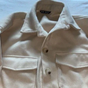 Beige kappa med knappar