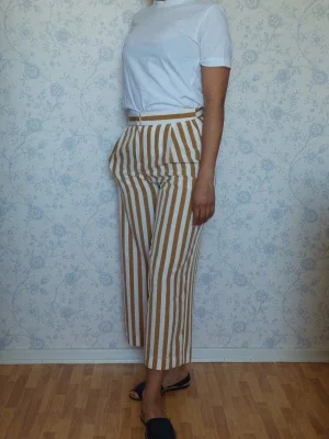 Randiga croppade byxor i beige och vitt