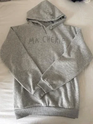 Grå hoodie med texten ”Ma Cherie”