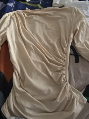 Beige omlottblus med rynkdetalj